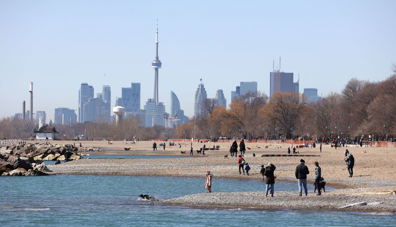 People are seen on a beach near Toronto on March 21.
