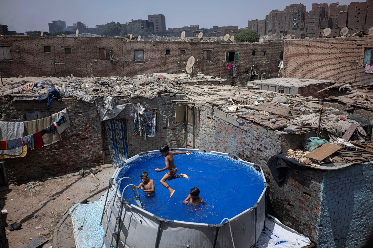 Boys cool down in a portable swimming pool in Cairo on Tuesday, July 29.