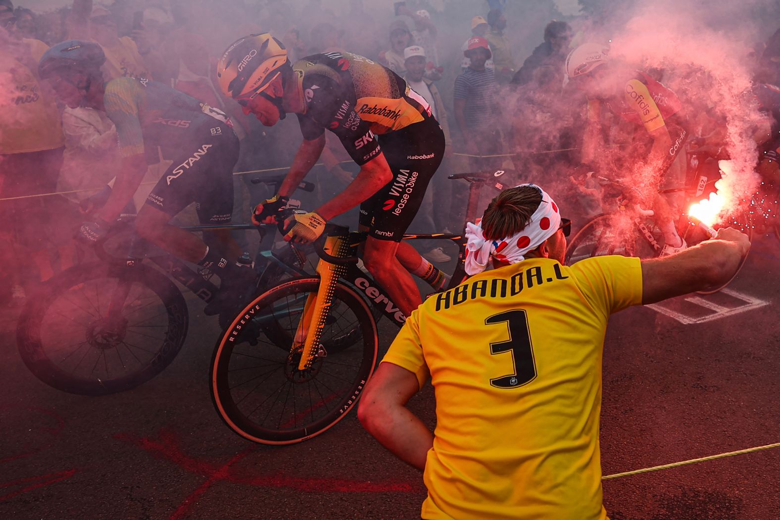 A spectator waves a flare as cyclists compete in the second stage of the Tour de France on Sunday, July 6.