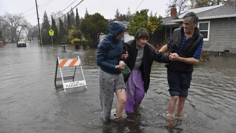 Nurse Katie Leonard, left, helps Scott Mathers, right, as they rescue Mathers' mother, Patsy Costello, who was trapped in her vehicle for over an hour Saturday in Pleasant Hill, California.