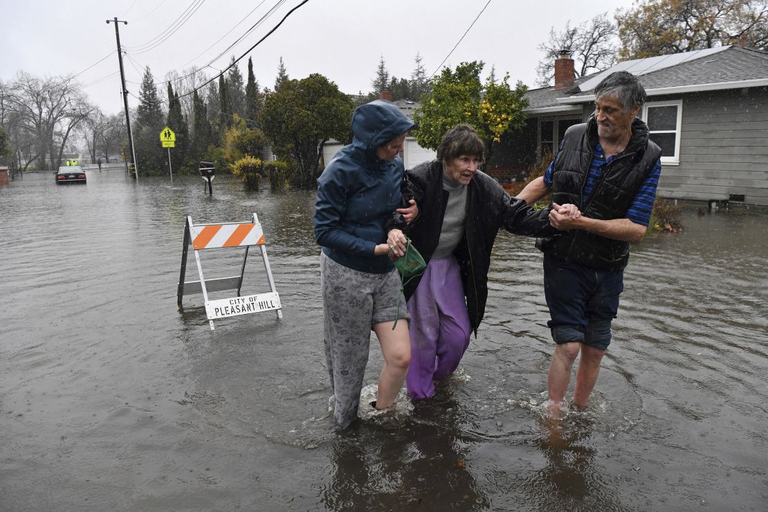 Nurse Katie Leonard, left, helps Scott Mathers, right, as they rescue Mathers' mother, Patsy Costello, who was trapped in her vehicle for over an hour Saturday in Pleasant Hill, California.