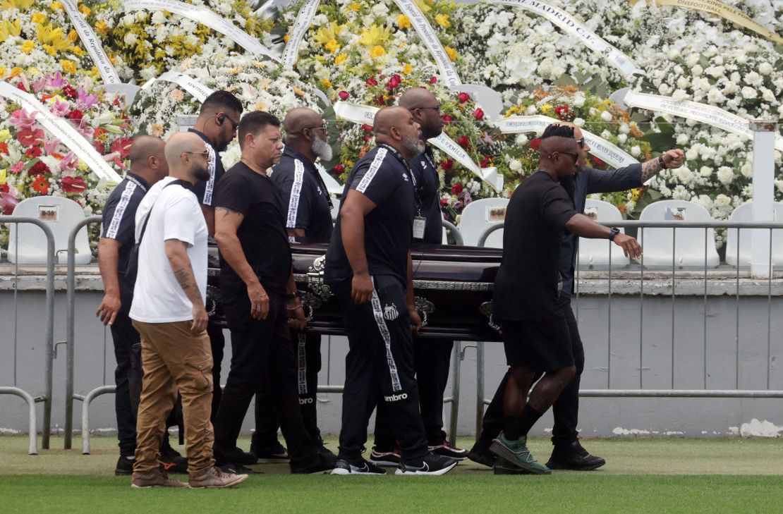 Pallbearers carry the casket of Brazilian soccer legend Pele to the centre circle of his former club Santos' Vila Belmiro stadium.