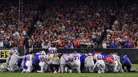 Buffalo Bills players huddle and pray after teammate Damar Hamlin collapsed on the field.