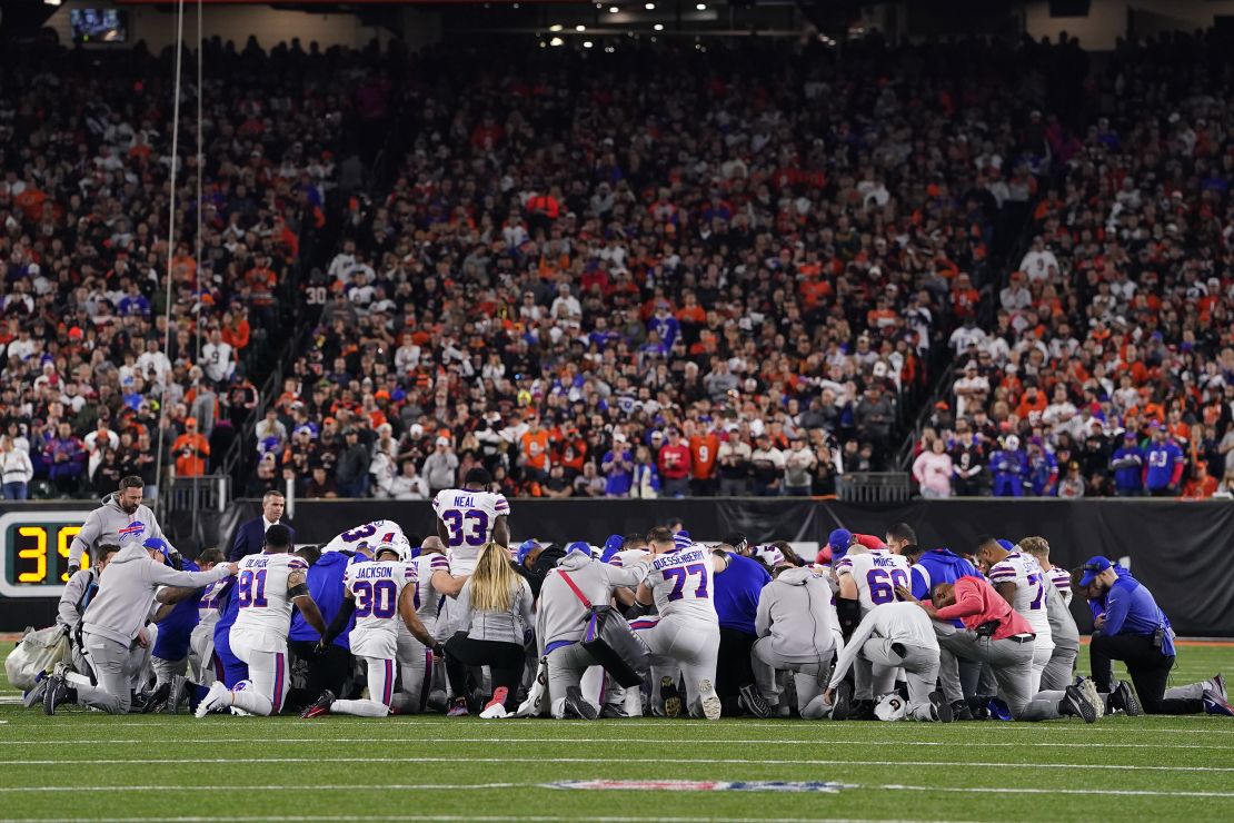 Buffalo Bills players huddle and pray after teammate Damar Hamlin collapsed on the field.