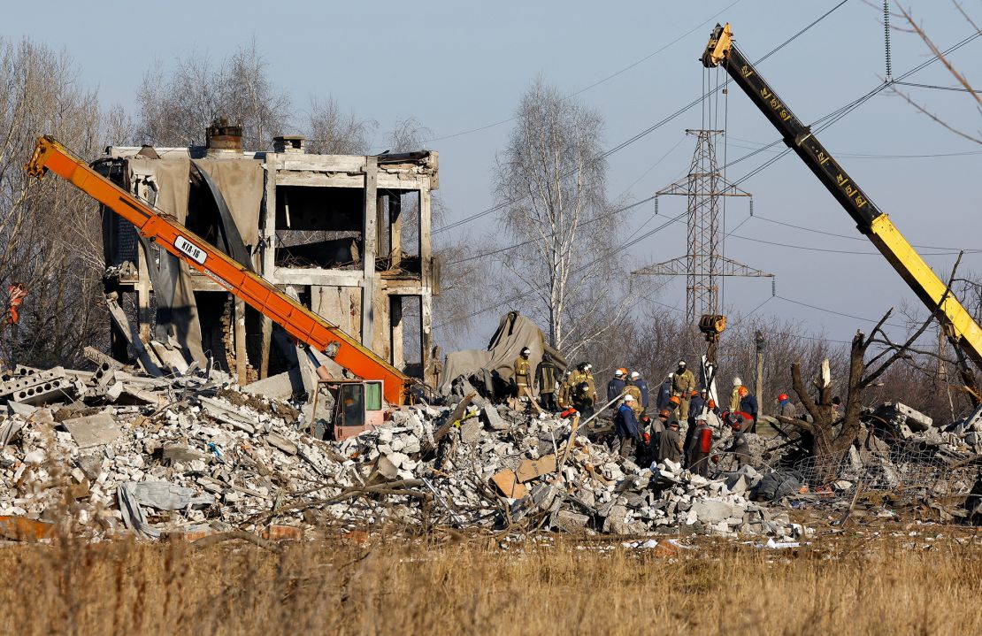 Workers are pictured on January 3, 2023 collecting debris at the site of the fatal attack in eastern Ukraine.
