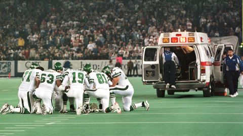 On December 21, 1997, Detroit Lions defender Reggie Brown is taken by ambulance, while members of the New York Jets kneel and pray in a circle.