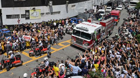 Pelé's coffin is taken through the streets on a fire engine.