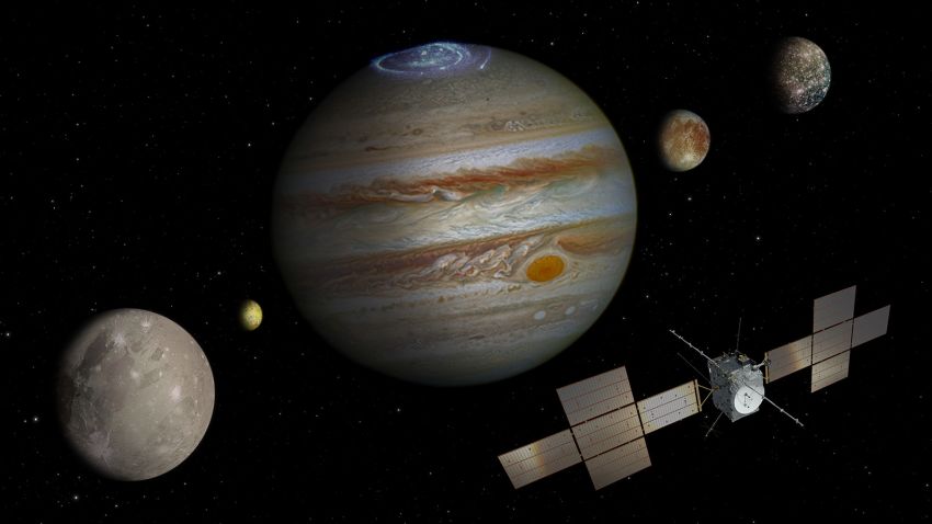 In the artist's impression, which is not to scale, Ganymede is shown in the foreground, Callisto to the far right, and Europa centre-right. Volcanically active moon Io is also shown, at left. The moons were imaged by NASA's Galileo spacecraft; Jupiter is seen here with a vivid aurora, captured by the NASA/ESA Hubble Space Telescope.