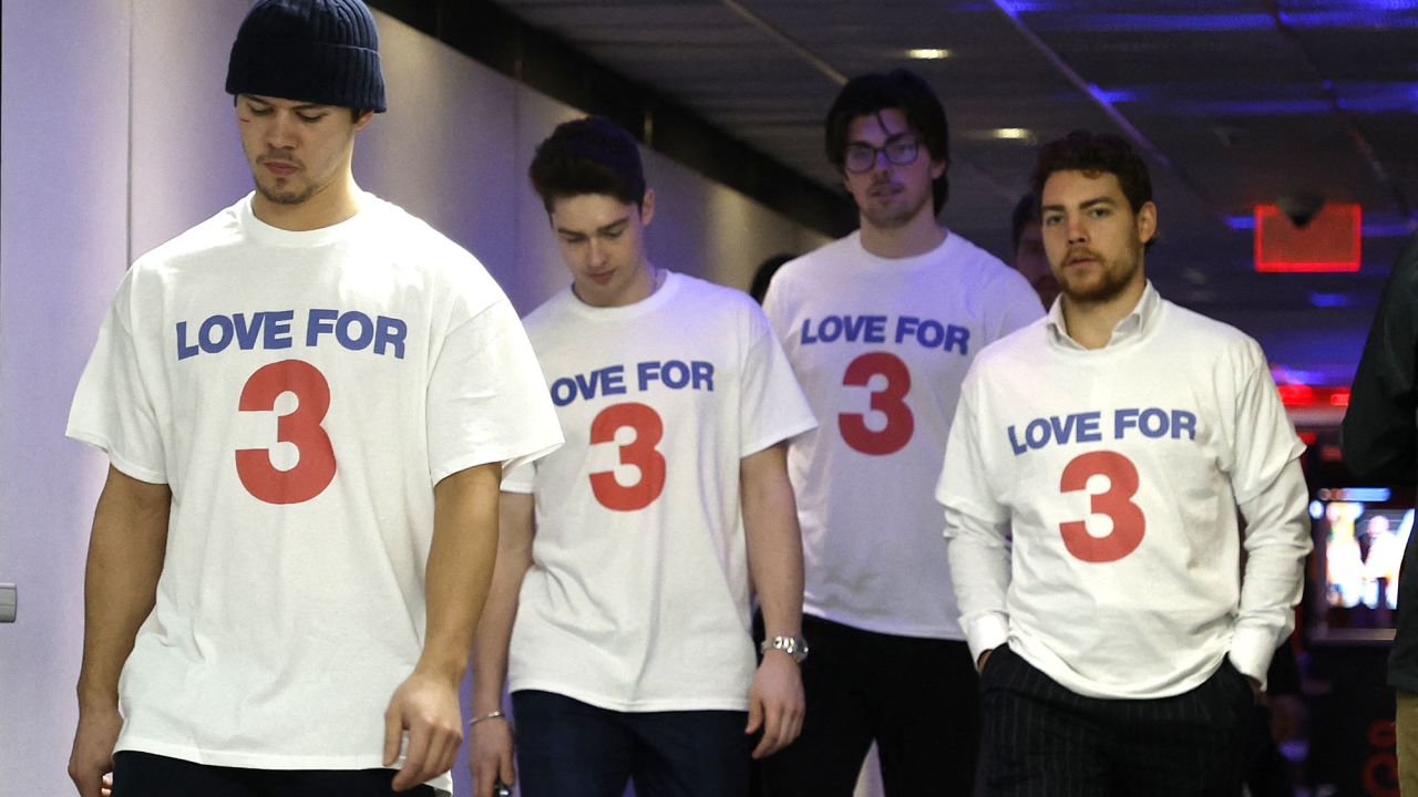 Buffalo Sabres players walk into their locker room wearing T-shirts in support of Damar Hamlin.