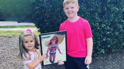 Layla, age 3, and Parker, age 6, holding a photo of their late half-sister Cayden, who died of the flu in 2014. 