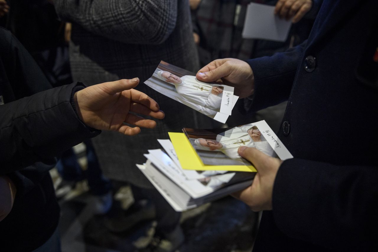 Pictures of Benedict are distributed outside St. Peter's Basilica on Tuesday.