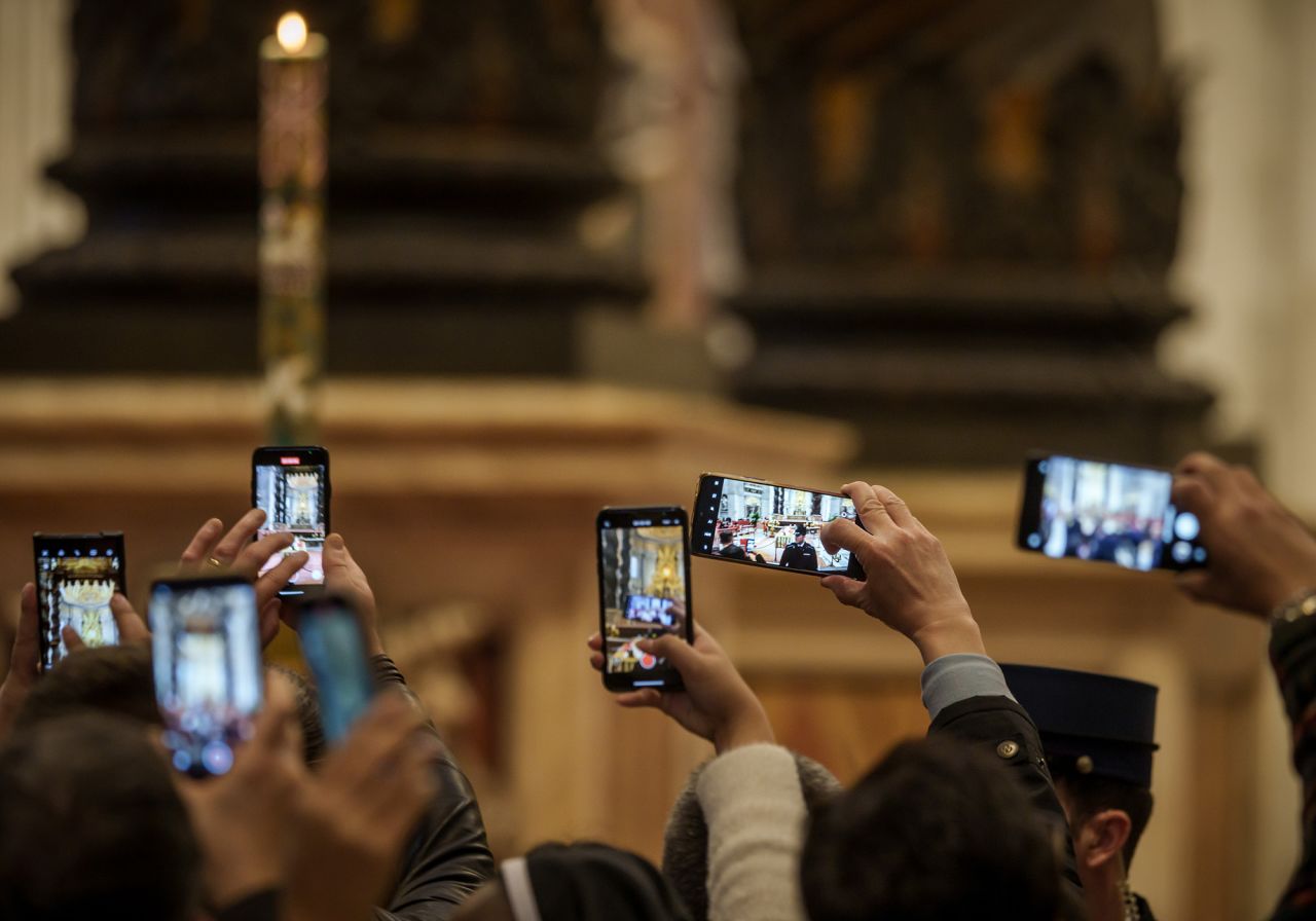 People take pictures of the late Pope on Monday.