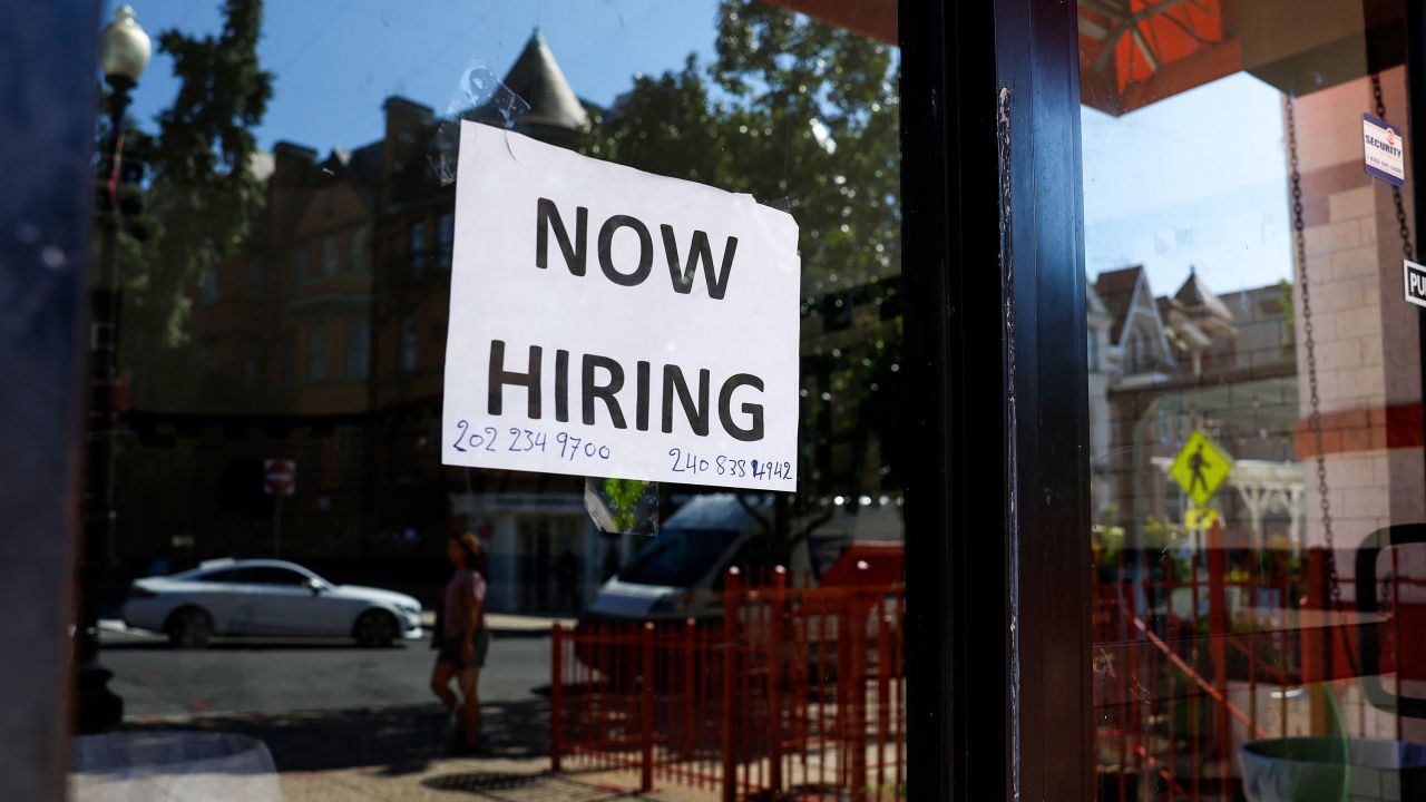 A "Now Hiring" sign is displayed on a storefront in Adams Morgan Neighborhood on October 07, 2022, in Washington, DC. 