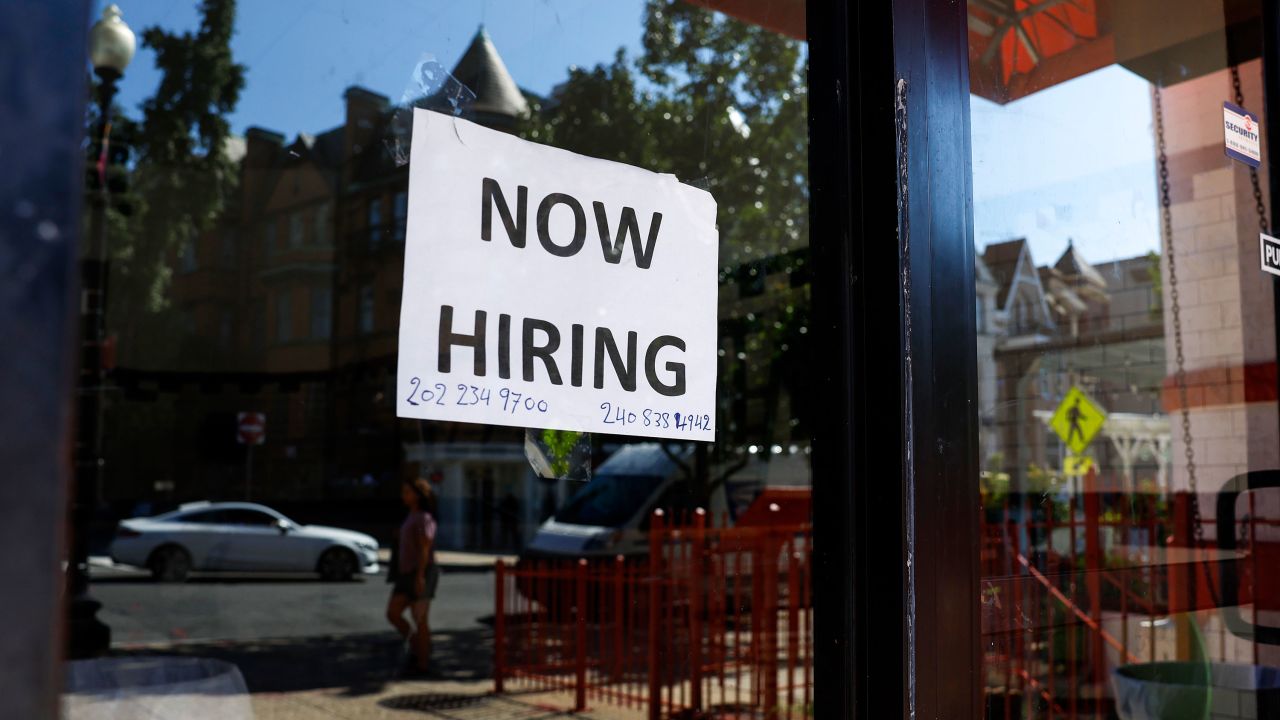 A "Now Hiring" sign is displayed on a storefront in Adams Morgan Neighborhood on October 07, 2022, in Washington, DC.