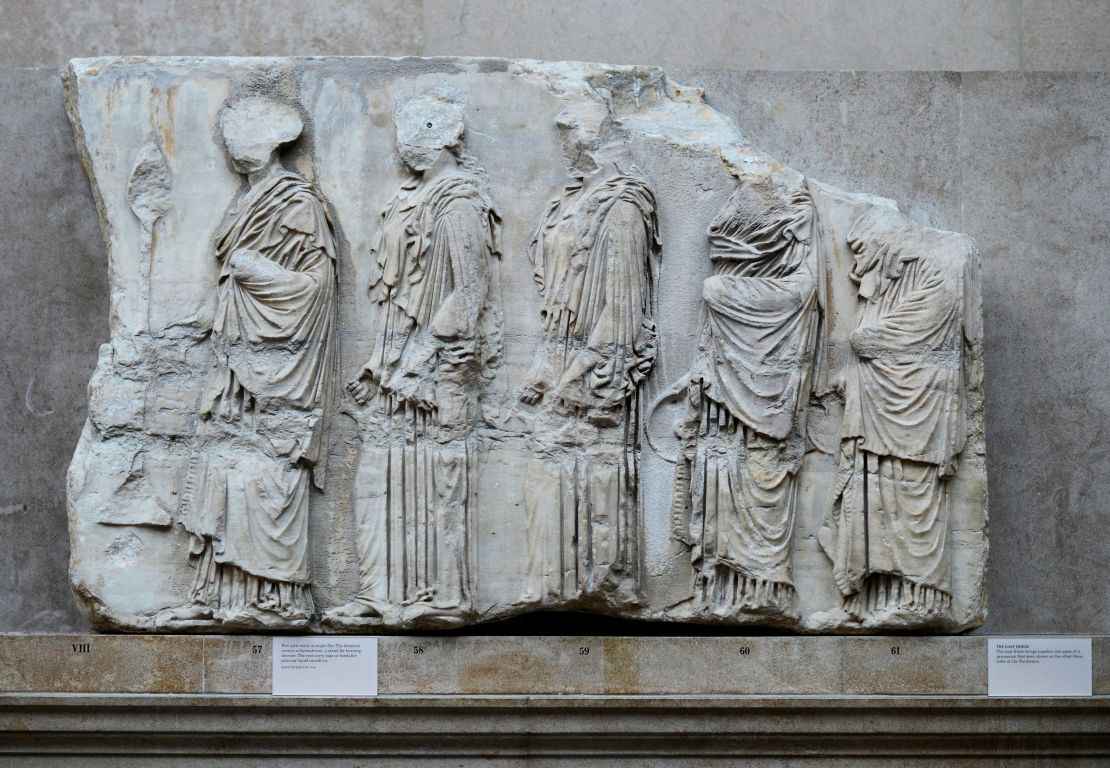 Five girls walk in a single file, part of a collection of stone objects, inscriptions and sculptures, known as the Elgin Marbles displayed at the Parthenon Marbles' hall at the British Museum in October 2014.