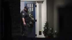 A law enforcement official stands at the front door of the Enoch, Utah, home where eight family members were found dead from gunshot wounds, Wednesday, Jan. 4, 2023. (Ben B. Brown/The Deseret News via AP)