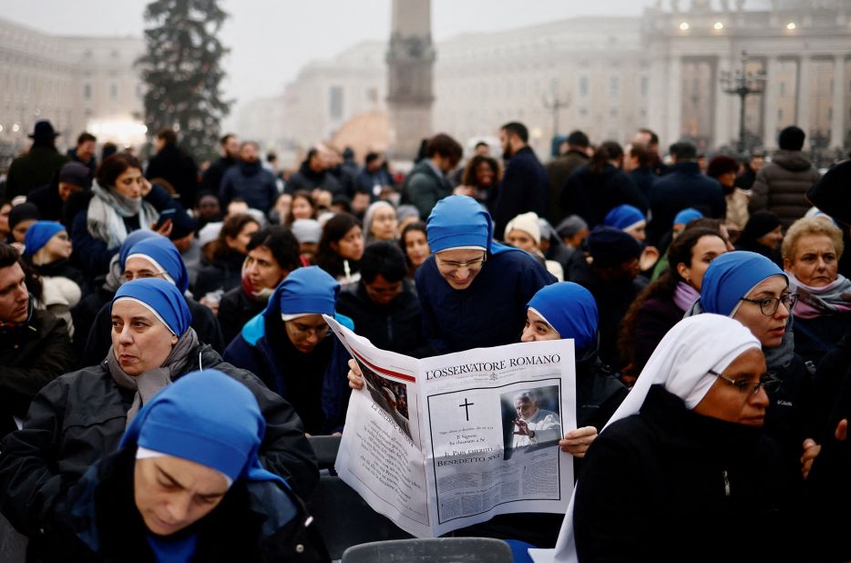 Nuns read L'Osservatore Romano at St. Peter's Square on the day of the funeral of former Pope Benedict at the Vatican.