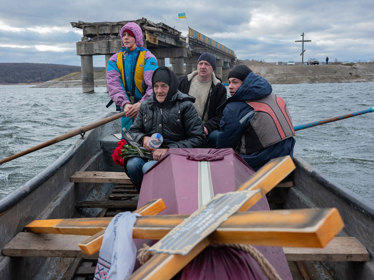 A woman transports the coffin of her son, who was killed while fighting Russian soldiers, across the Siverskyi-Donets river near Staryi Saltiv, Ukraine, on Wednesday, January 4.