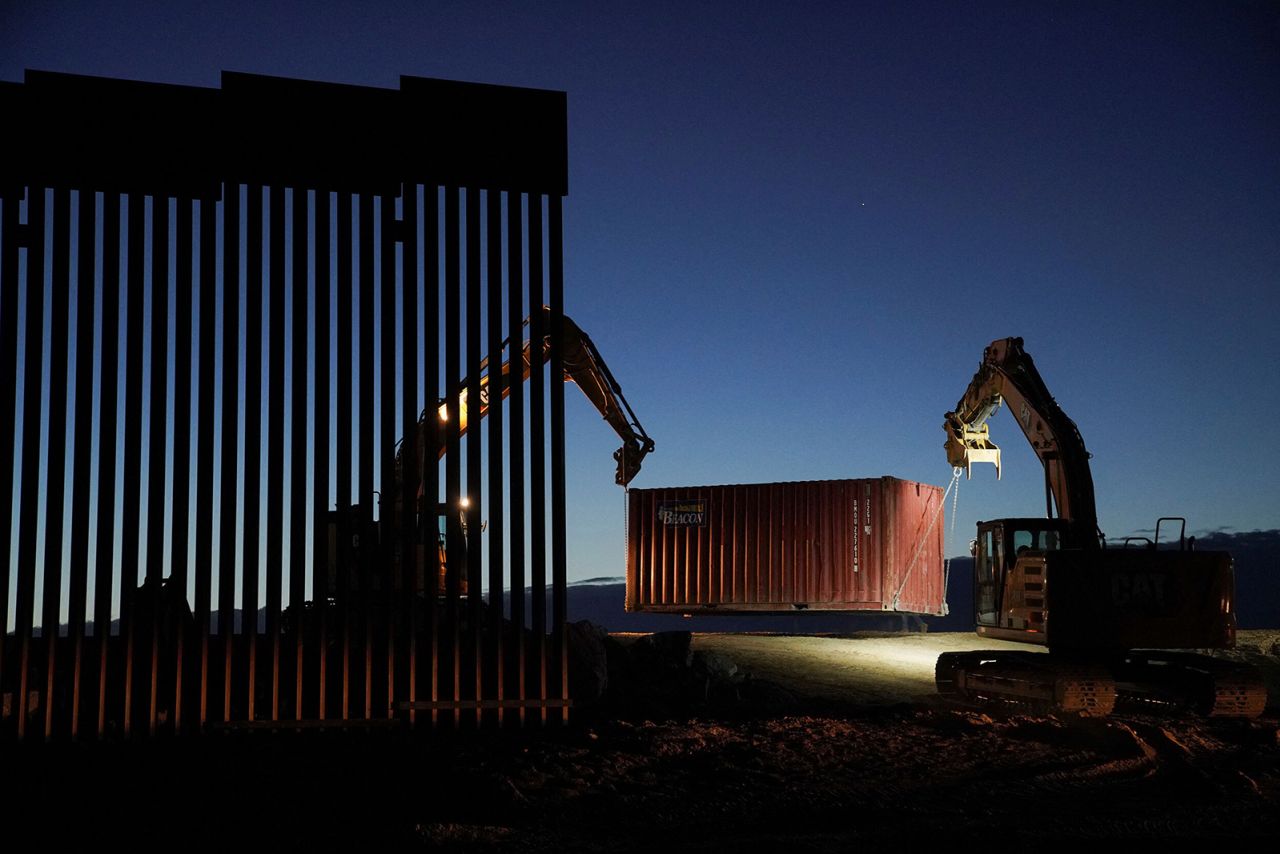 A construction crew removes shipping containers in Yuma County, Arizona, early on Tuesday, January 3. The state of Arizona agreed to remove the shipping containers, which were placed as a makeshift wall along its shared border with Mexico, <a href="https://www.cnn.com/2022/12/22/us/border-wall-shipping-container-arizona-lawsuit/index.html" target="_blank">as part of an ongoing lawsuit</a>.