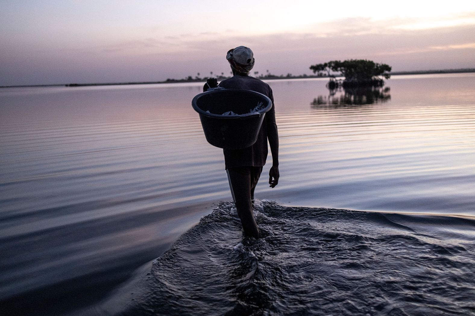 A prawn fisherman walks into the Saloum Delta ahead of a night of fishing in Simal, Senegal, on Tuesday, January 3. Prawn fishermen will spend up to three hours each night walking large distances across the delta, dragging a net to catch prawns. <a href="http://www.cnn.com/2022/12/29/world/gallery/photos-this-week-december-22-december-29/index.html" target="_blank">See last week in 36 photos</a>.