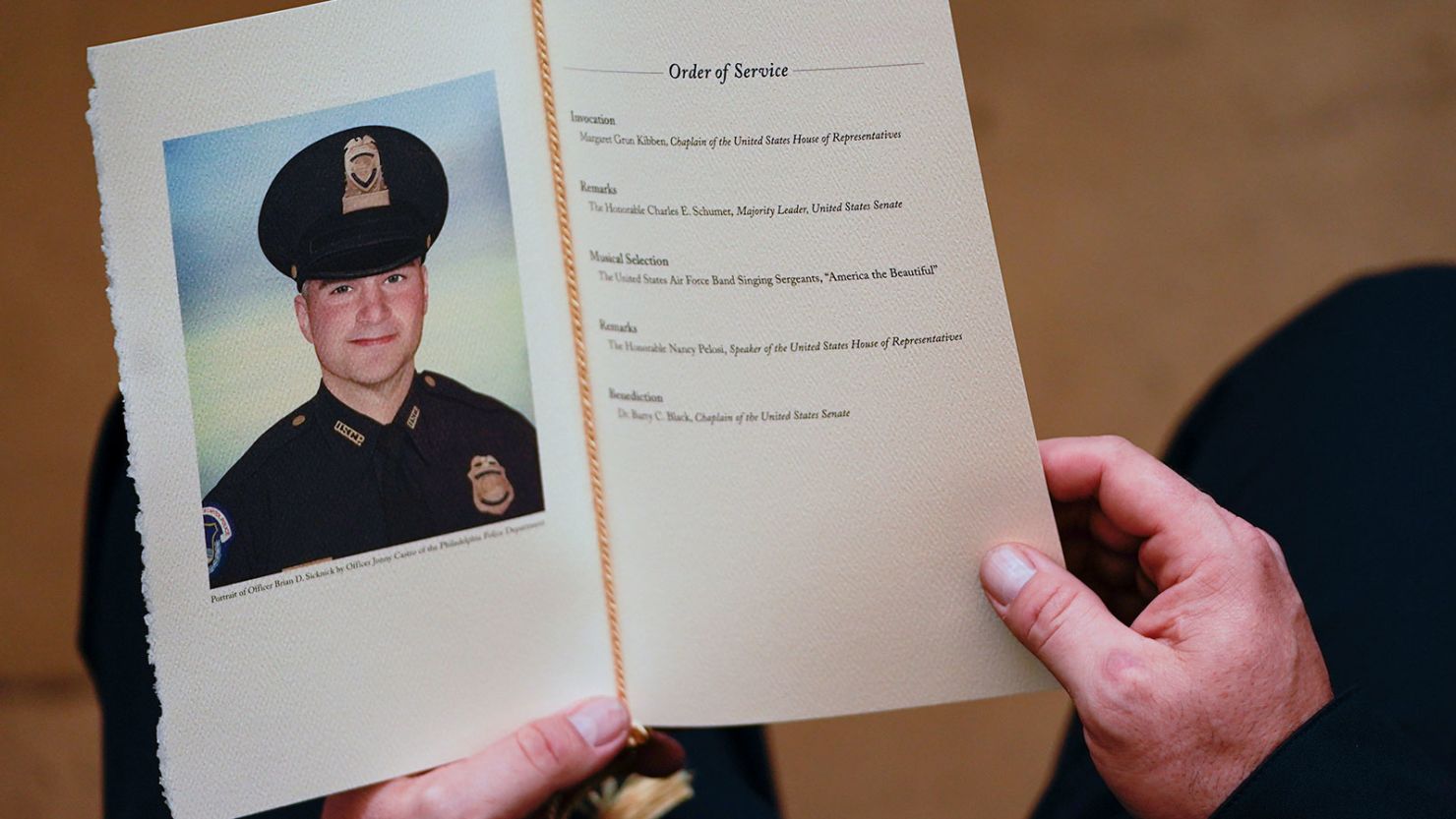 In this February 3, 2021 photo, a US Capitol Police Officer holds a program during a ceremony memorializing Brian Sicknick in Washington. Sicknick's estate filed a lawsuit Thursday.