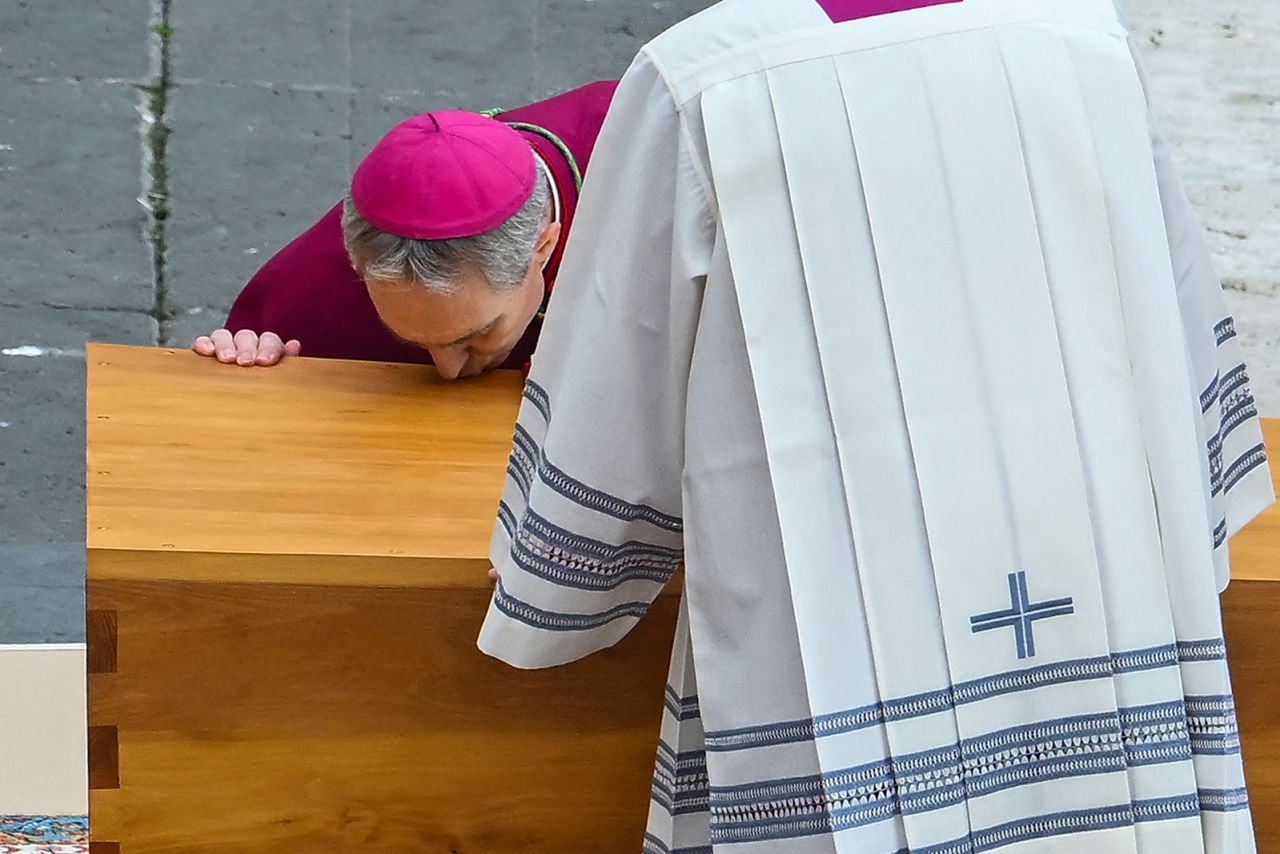 German Archbishop Georg Gaenswein kisses the coffin of Pope Emeritus Benedict XVI at the start of his funeral mass at St. Peter's Square in the Vatican.