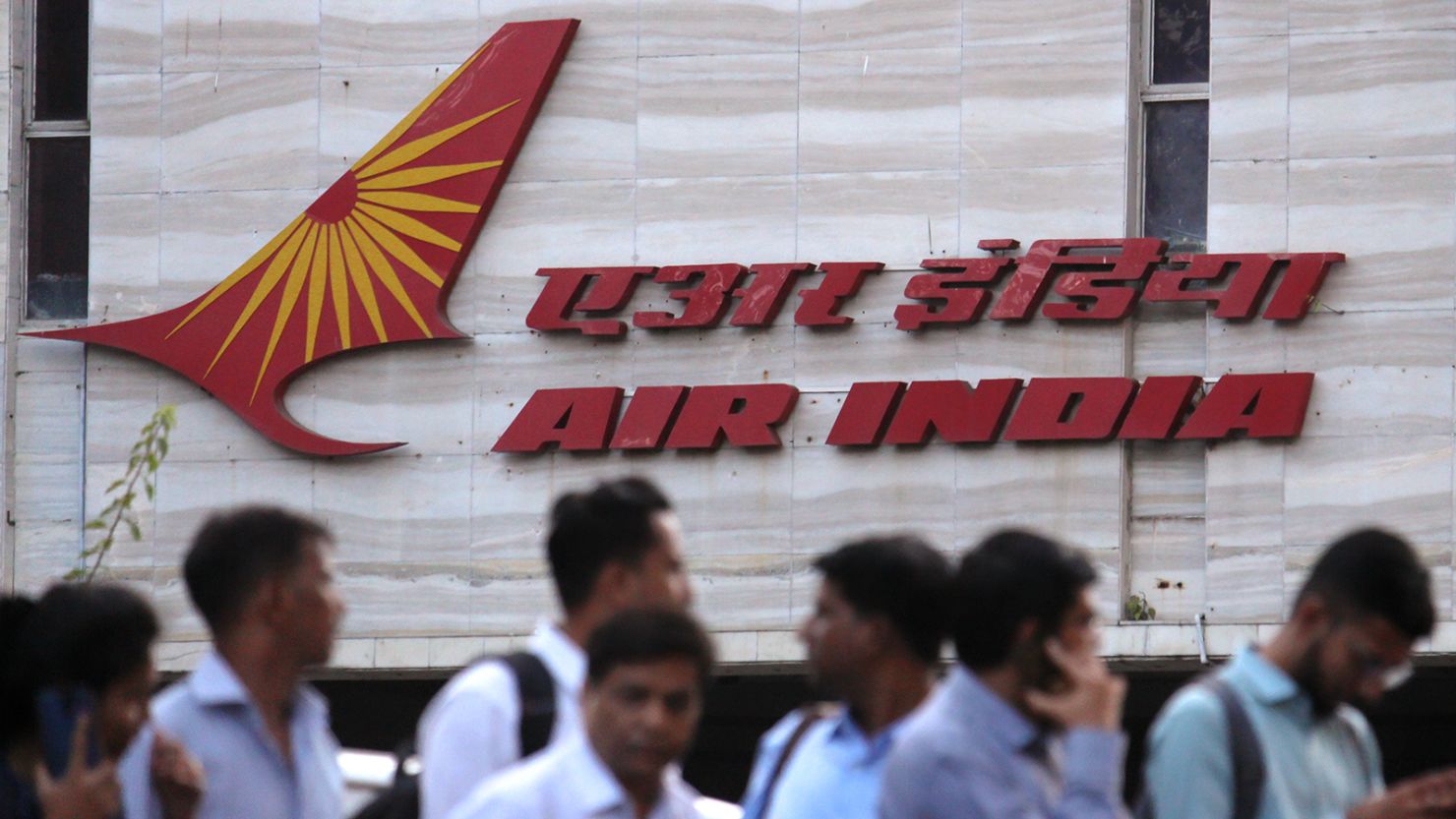 People walk past an Air India logo outside its building in Mumbai, India on 28 January 2020. 