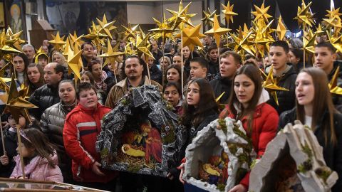 Young people hold a Birth of Christ diorama during a religious service to celebrate the Orthodox Christmas in St. Clement Cathedral in Skopje on January 6.