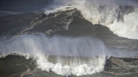 A surfer rides a wave in Praia do Norte, Nazaré, Portugal on February 25, 2022.