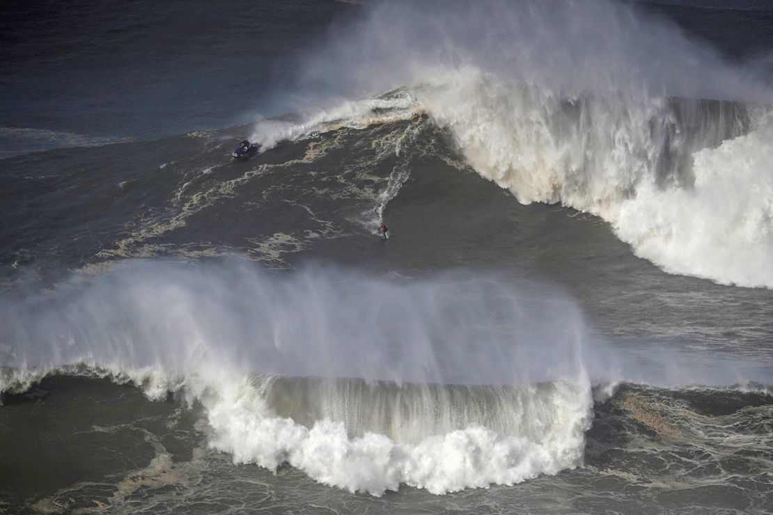A surfer rides a wave in Praia do Norte, Nazaré, Portugal on February 25, 2022.