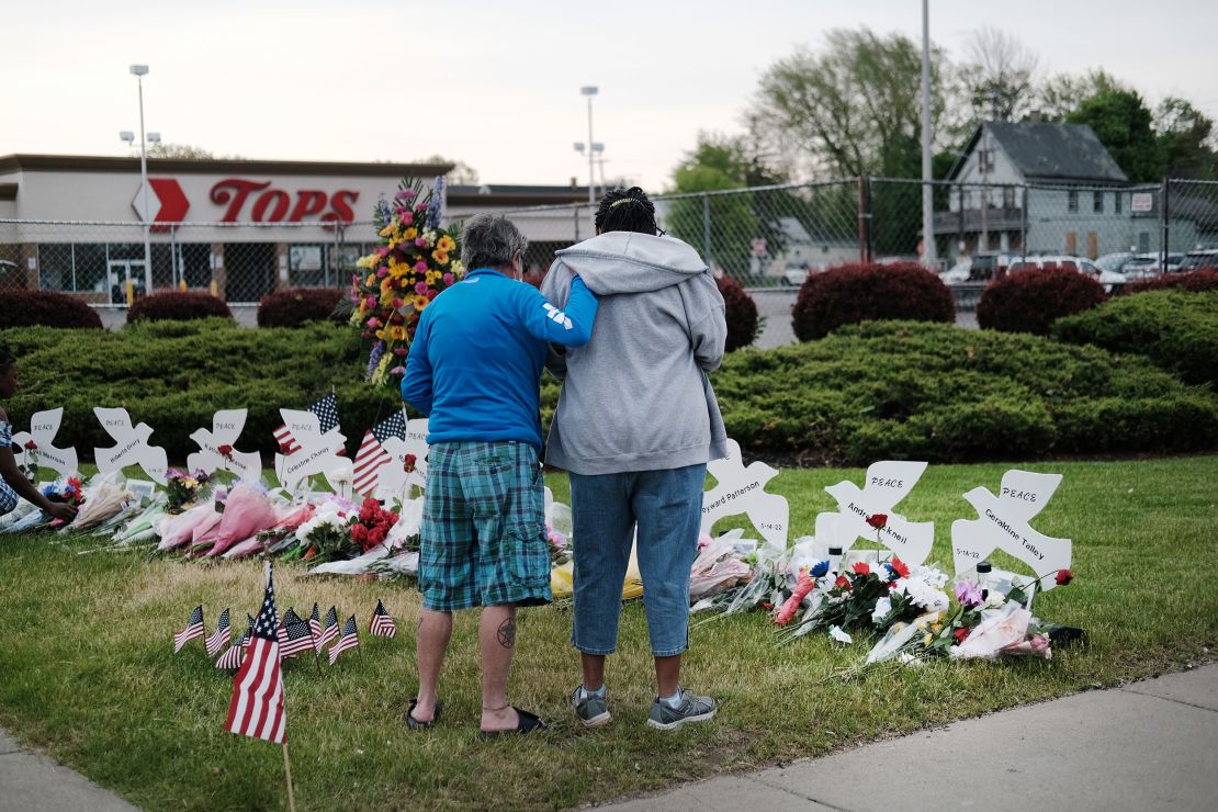 BUFFALO, NEW YORK - MAY 20: People gather at a memorial for the shooting victims outside of Tops market on May 20, 2022 in Buffalo, New York. 18-year-old Payton Gendron is accused of the mass shooting that killed 10 people at the Tops grocery store on the east side of Buffalo on May 14th and is being investigated as a hate crime.