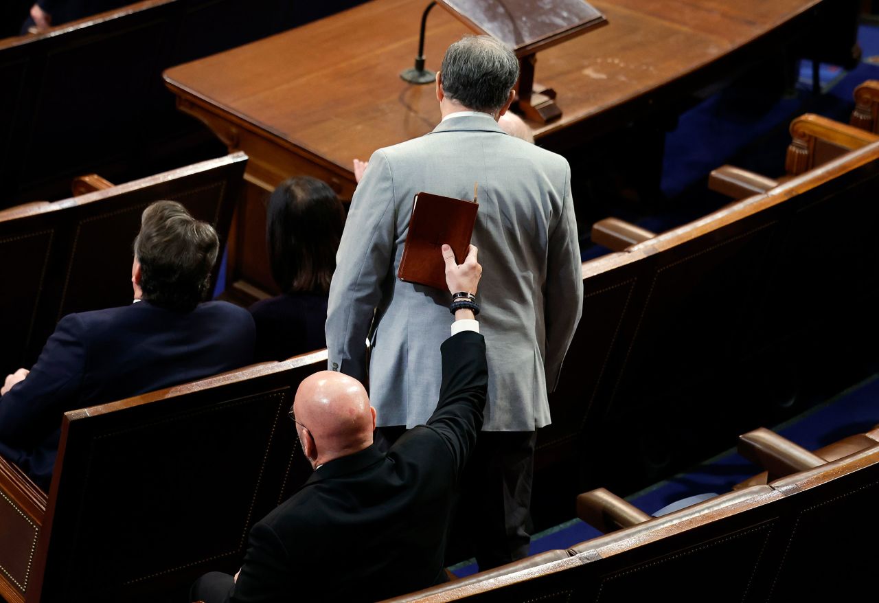 US Rep. Clay Higgins puts a Bible on Clyde's back as he votes for McCarthy on Friday.