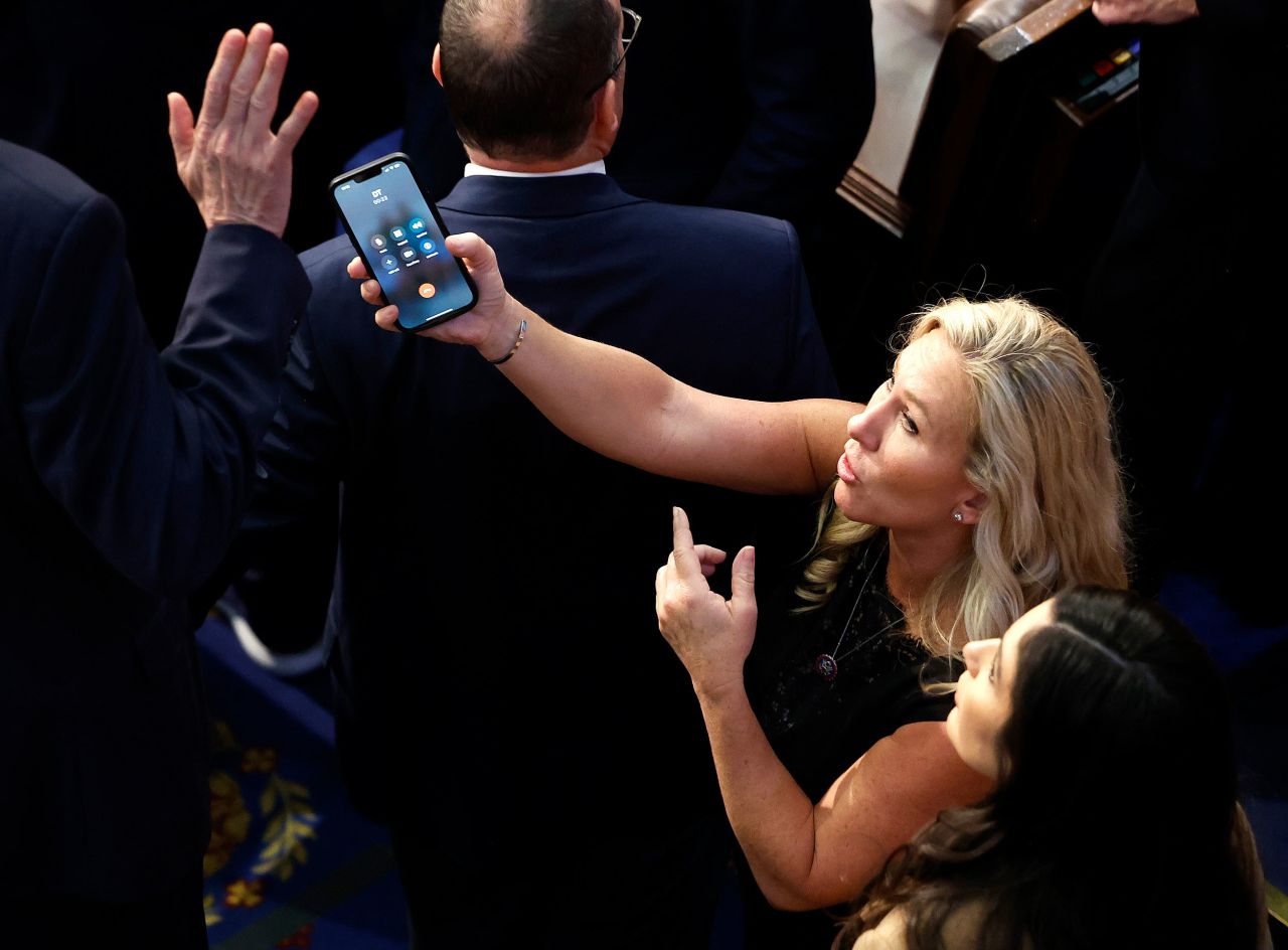 US Rep. Marjorie Taylor-Greene, a Republican from Georgia, holds a phone with the initials 