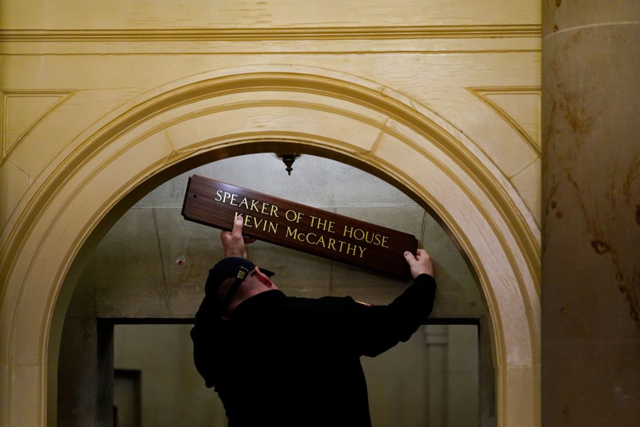 A worker replaces a sign over McCarthy's office on Saturday.