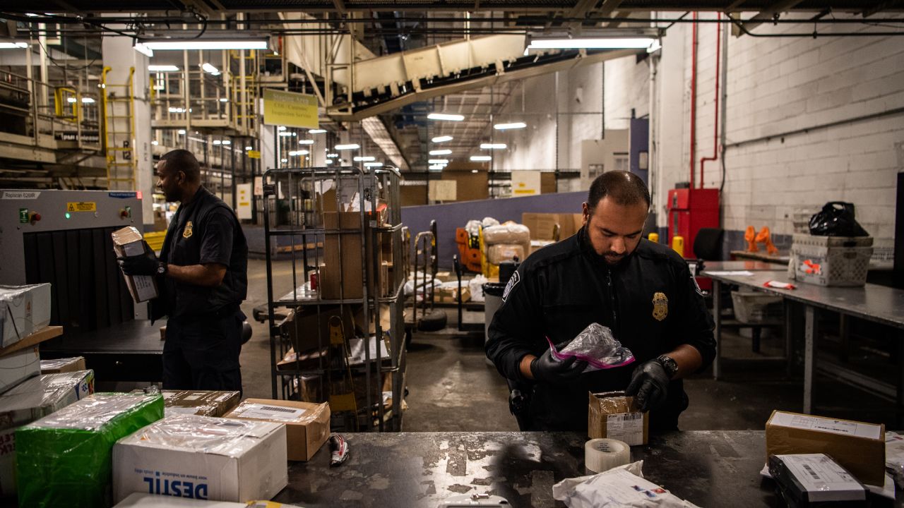 Customs and Border Protection Officer Mohammed Rahman holds a bag filled with white powder for testing at the JFK International Mail Facility on Friday, September 7, 2018, in Jamaica, New York.