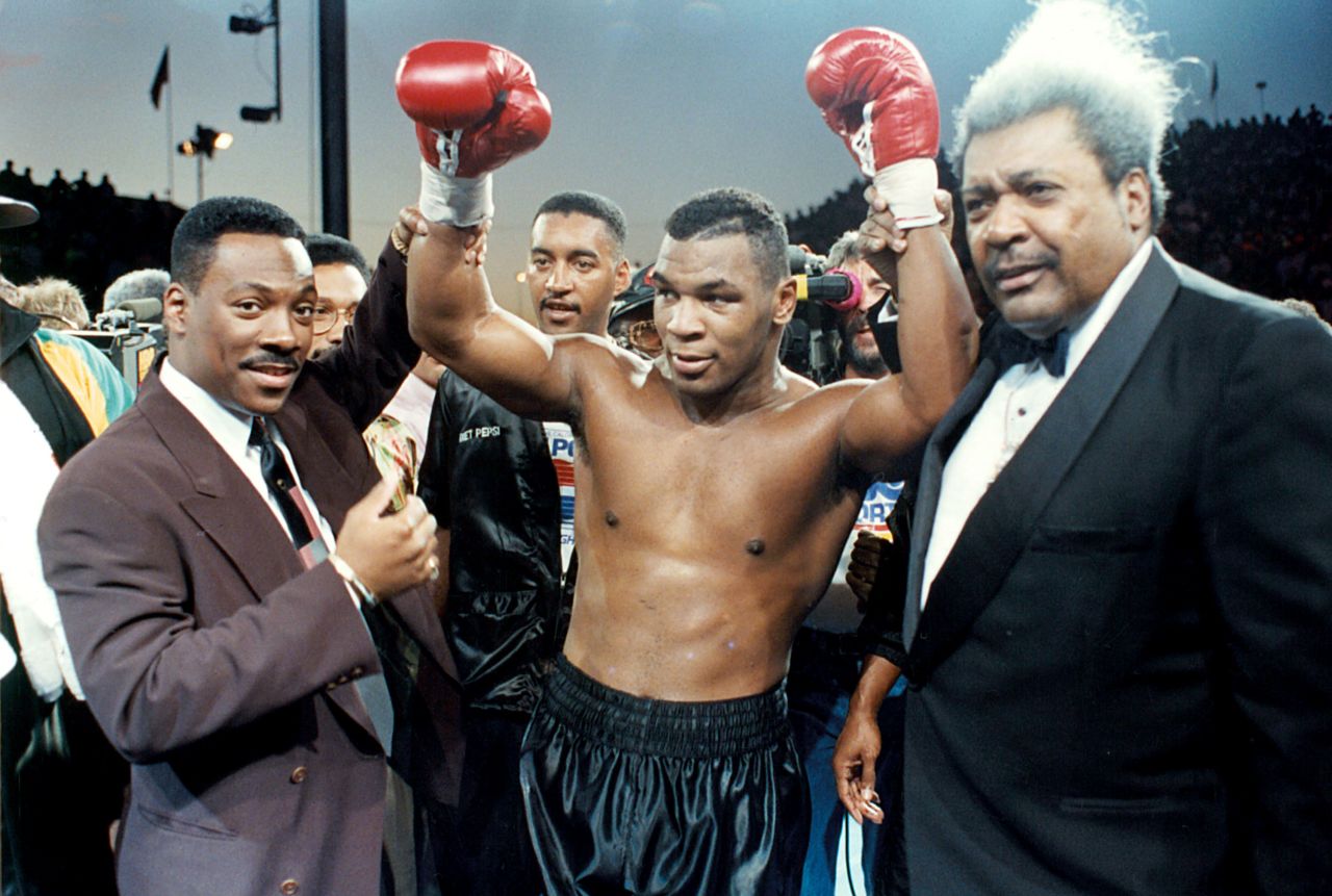 Murphy raises the hand of boxer Mike Tyson before a 1990 bout in Las Vegas.