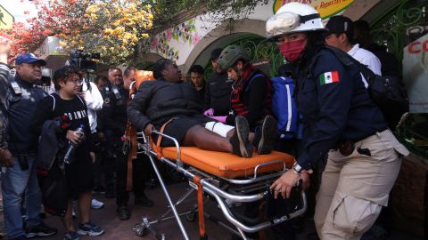 Paramedics assist a woman after a train collision in Mexico City on January 7, 2023.