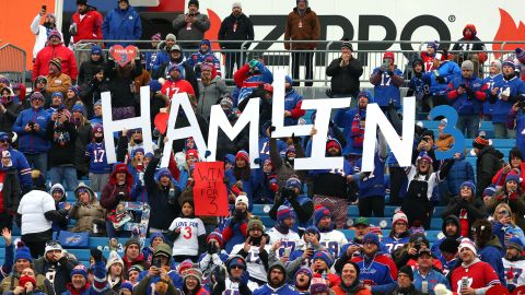 Fans van Buffalo Bills houden voor de wedstrijd van zondag borden ter ondersteuning van Demar Hamlin.