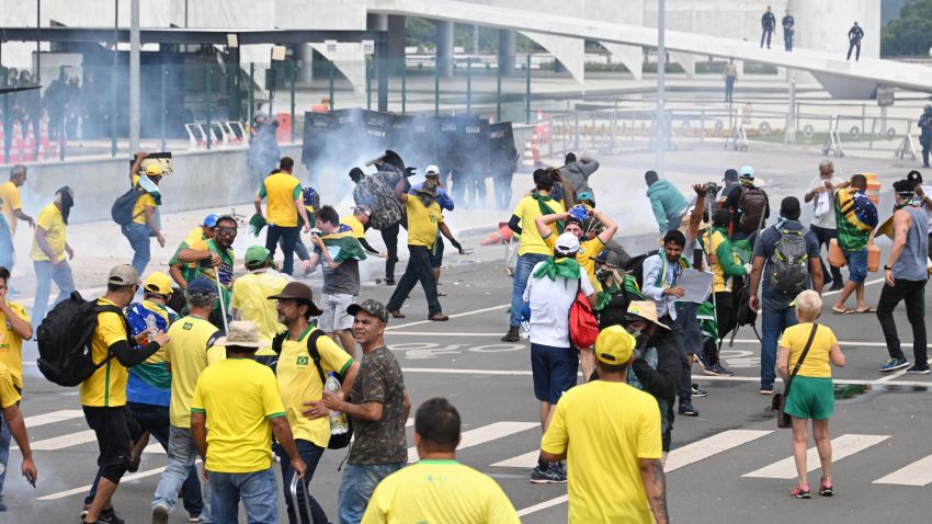 Supporters of Brazilian former President Jair Bolsonaro clash with the police during a demonstration outside the Planalto Palace in Brasilia on January 8, 2023. - Brazilian police used tear gas Sunday to repel hundreds of supporters of far-right ex-president Jair Bolsonaro after they onto Congress grounds one week after President Luis Inacio Lula da Silva's inauguration, an AFP photographer witnessed. (Photo by EVARISTO SA / AFP) (Photo by EVARISTO SA/AFP via Getty Images)