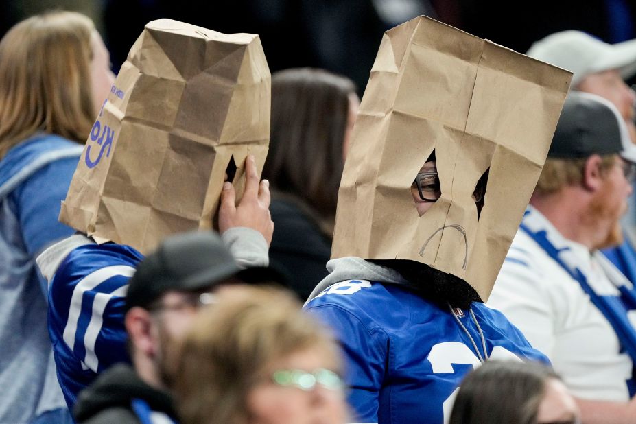 Indianapolis Colts fans sit in the stands wearing sad face paper bag masks during a game against the Houston Texans at Lucas Oil Stadium. The Colts lost their last seven games of the season -- including Sunday's 32-31 defeat to the Texans -- to finish 4-12-1 for the season, leaving them with the No. 4 pick in the 2023 NFL draft. 