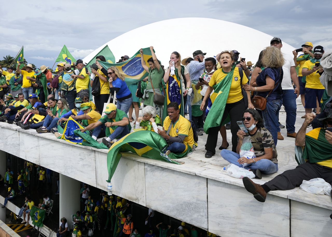 Supporters of former President Jair Bolsonaro stand on the roof of the National Congress building.