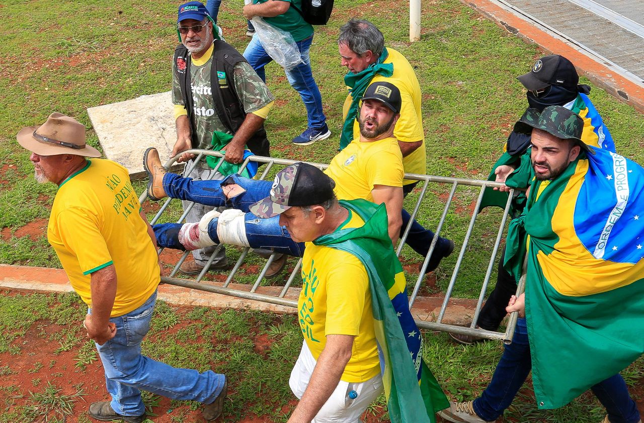  A supporter of Brazilian former President Jair Bolsonaro is evacuated by fellow supporters after being wounded during clashes with riot police outside the Planalto presidential palace.