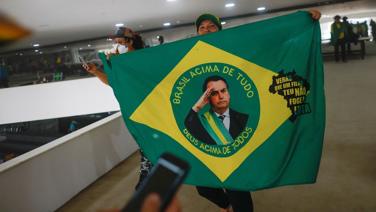 A supporter of Jair Bolsonaro holds a flag depicting Brazil's former president on Sunday.