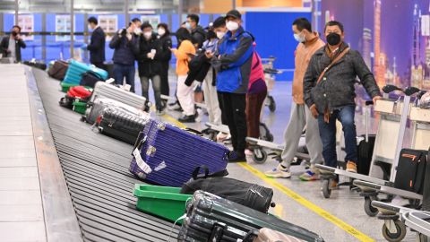Travelers wait for their luggage at the baggage claim area at Shanghai Pudong International Airport as China lifts quarantine requirements for international arrivals on January 8, 2023 in Shanghai, China.
