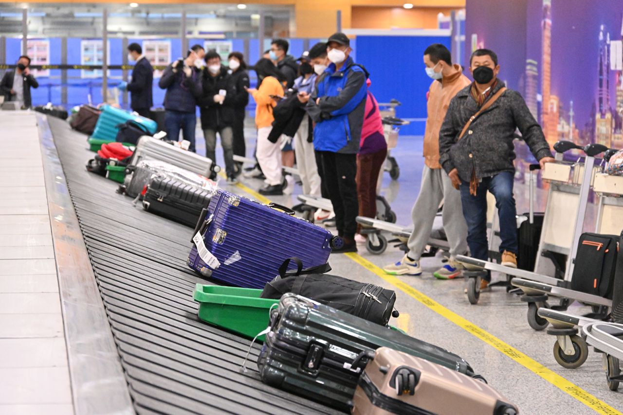 Travelers wait for their luggage at the baggage claim area at Shanghai Pudong International Airport as China lifts quarantine requirements for international arrivals on January 8, 2023 in Shanghai, China.