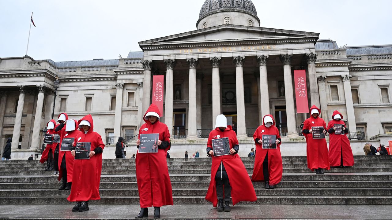 Protesters wearing 'Handmaid's Tale' costumes hold placards during a silent march in central London on January 7 to raise awareness about the recent women-led uprising in Iran.