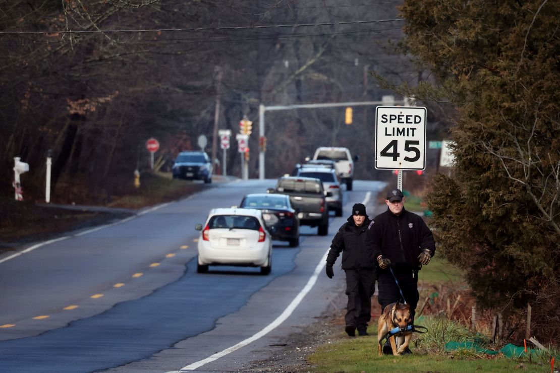 Members of a State Police K-9 unit search along a highway in Cohasset, Massachusetts, on January 7.
