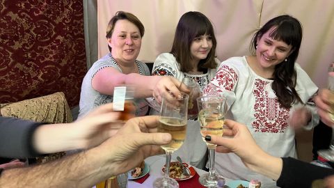 Elena Molchanova, an infectious diseases specialist on the left, and the neurosurgeon Elena Manukhina on the right, two of the seven remaining doctors in Bakhmut, toast at Christmas dinner.