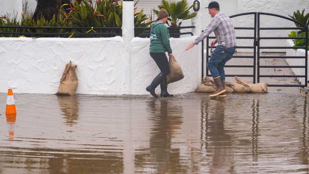 Owners of a restaurant in Aptos, California, place sandbags in front of their establishment Monday. 