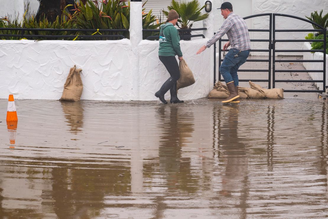 Owners of a restaurant in Aptos, California, place sandbags in front of their establishment Monday. 